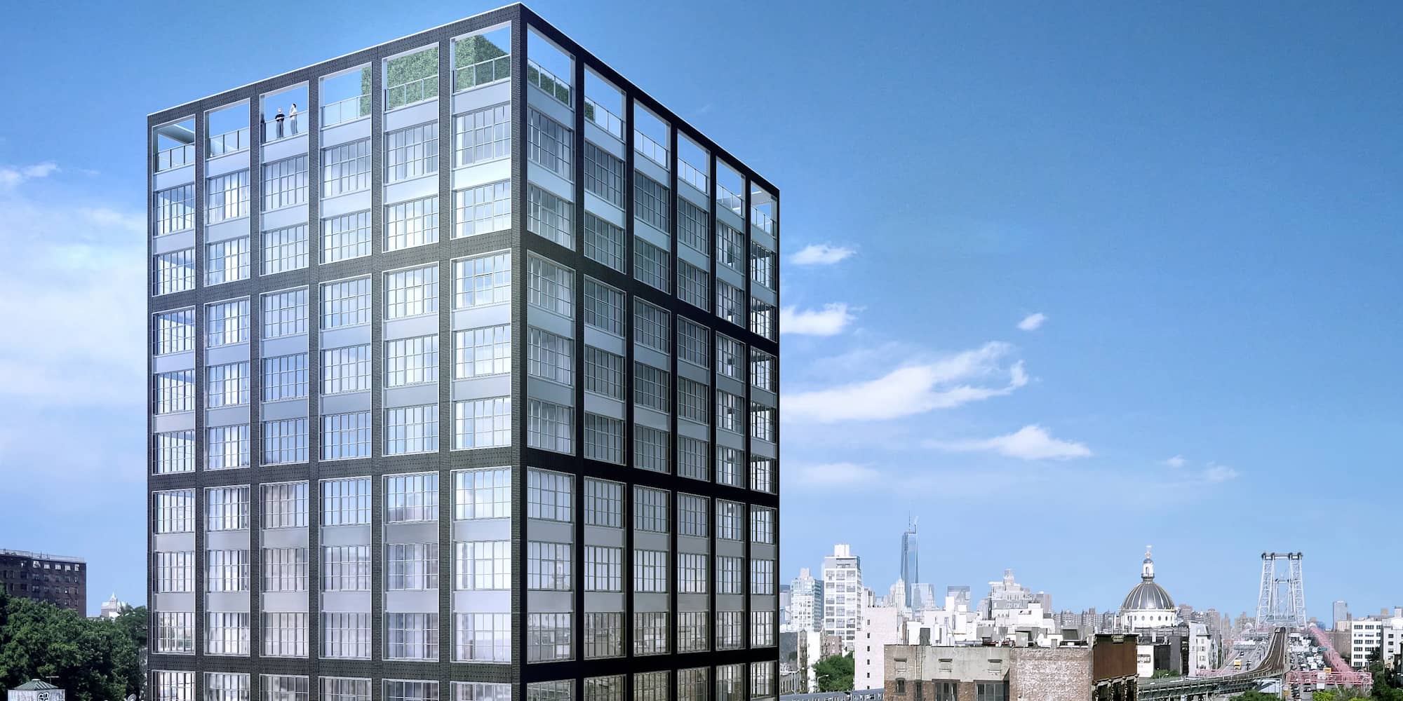 A modern glass and steel high-rise building with a rooftop terrace, set against a city skyline under a clear blue sky.